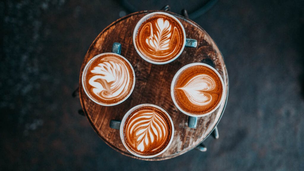 Four espresso drinks showing off impressive latte art