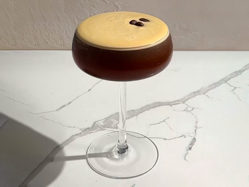 Freshly made espresso martini on marble countertop