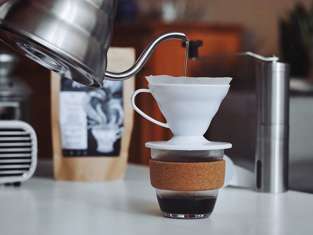 Hario V60 coffee setup - coffee cone on top of mug, gooseneck kettle and coffee grinder