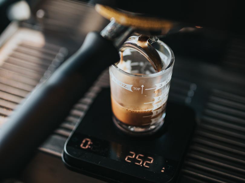 Weighing a shot of ristretto as it is freshly pulled from an espresso machine