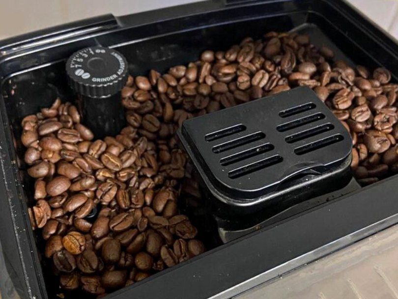 Bean hopper and grind adjustment dial on DeLonghi espresso machines