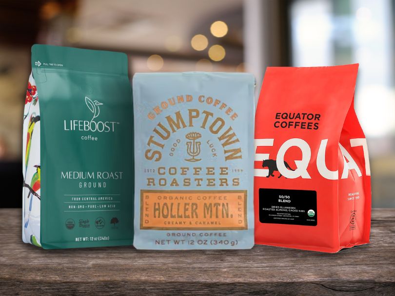 Three bags of coffee beans on a table (from Lifeboost, Stumptown, and Equator)