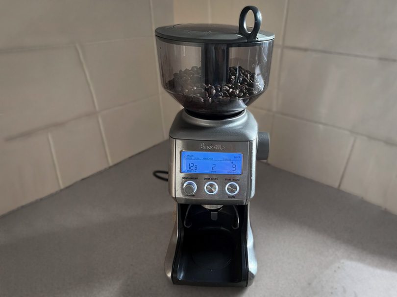 Breville Smart Grinder Pro with coffee beans in the hopper and screen turned on
