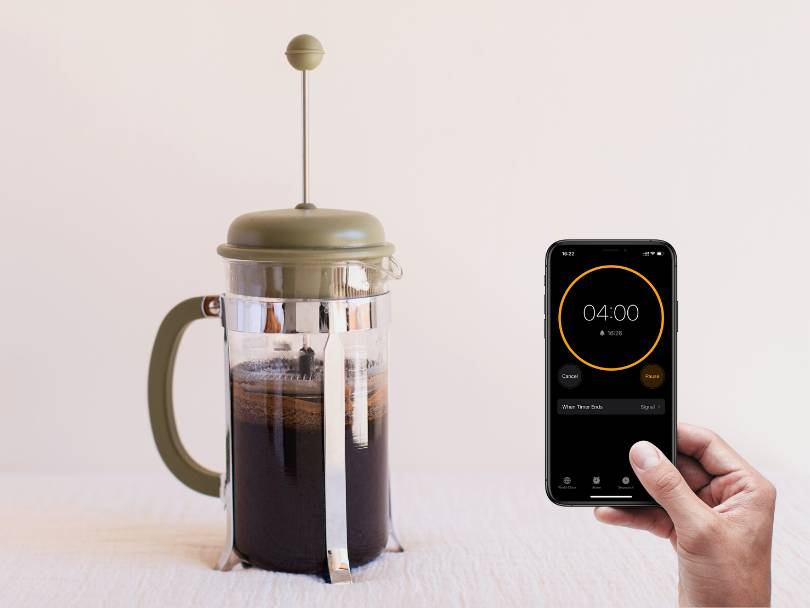 Timer set to 4 minutes beside French press coffee maker