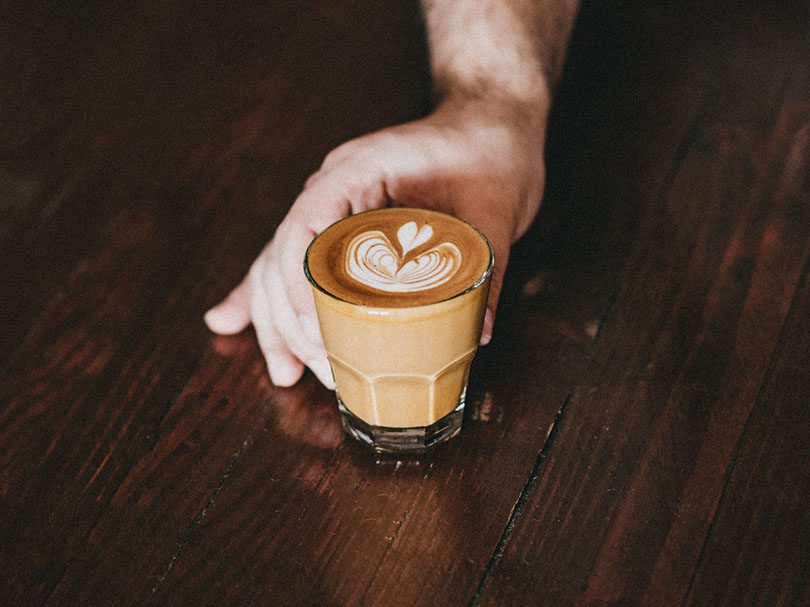 Hand pushing a magic coffee towards the front of the table