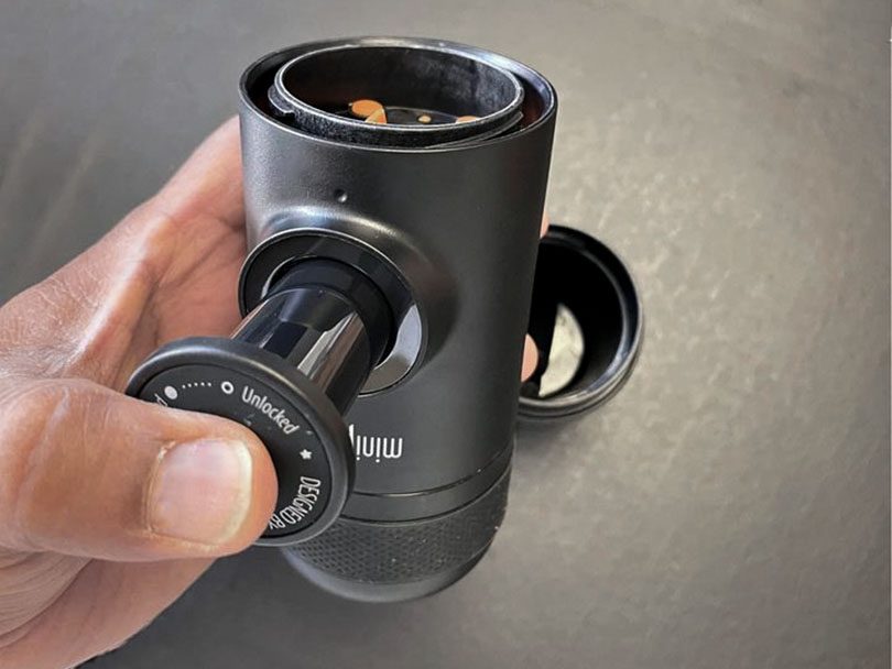 Hand using the pump mechanism on the Nespresso NS - top off to show where Nespresso pods go