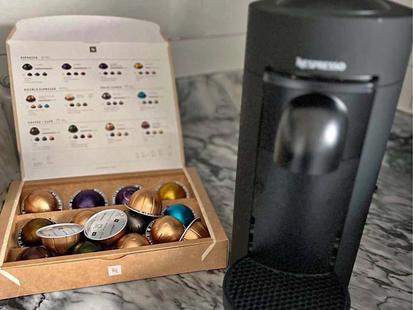 Box of Nespresso Vertuo coffee pods beside the Vertuo Plus coffee maker