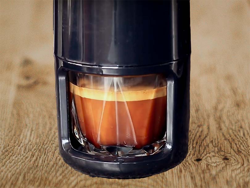 Close up of the glass cup under the Staresso portable espresso maker with a freshly pulled shot of espresso