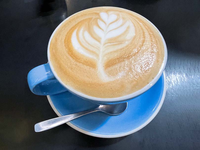Caffe latte with latte art in a blue cup