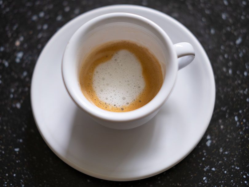 Top down view of a macchiato - a short espresso drink with a splash of milk foam