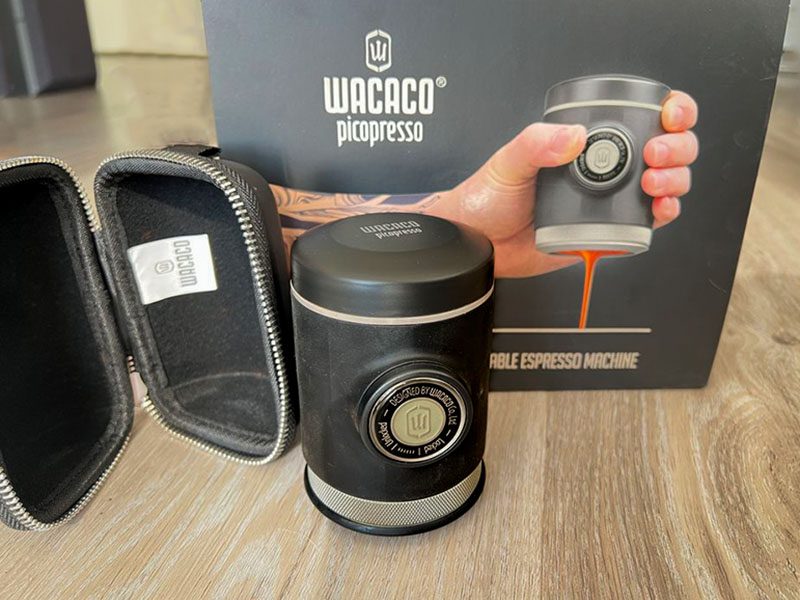 Wacaco Picopresso on wooden table beside its case and the box