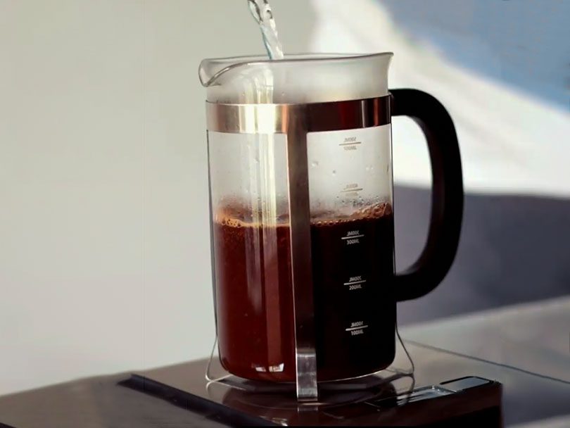 French press coffee maker on the scales, weighing the correct amount of water to coffee ratio