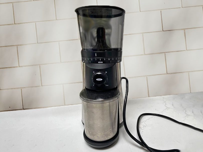 Front view of the OXO Brew conical burr grinder with cable off to the side