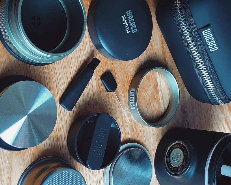 All the parts and accessories of the Wacaco Picopresso laid out on table