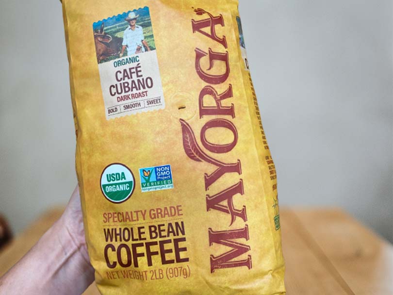 Holding a bag of Mayorga Organics Coffee - Cafe Cubano Dark Roast