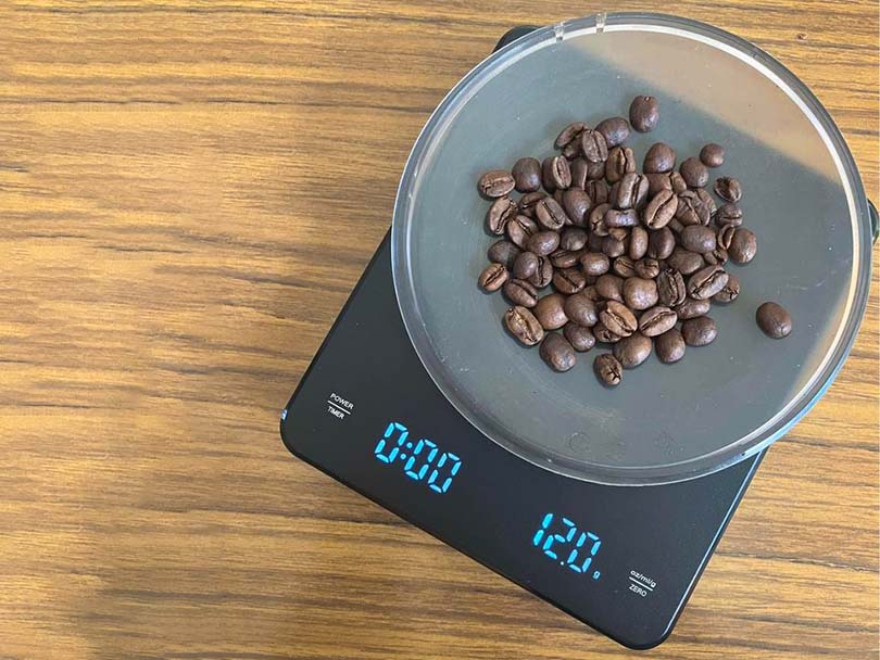 Bowl of coffee beans weighed on digital coffee scales