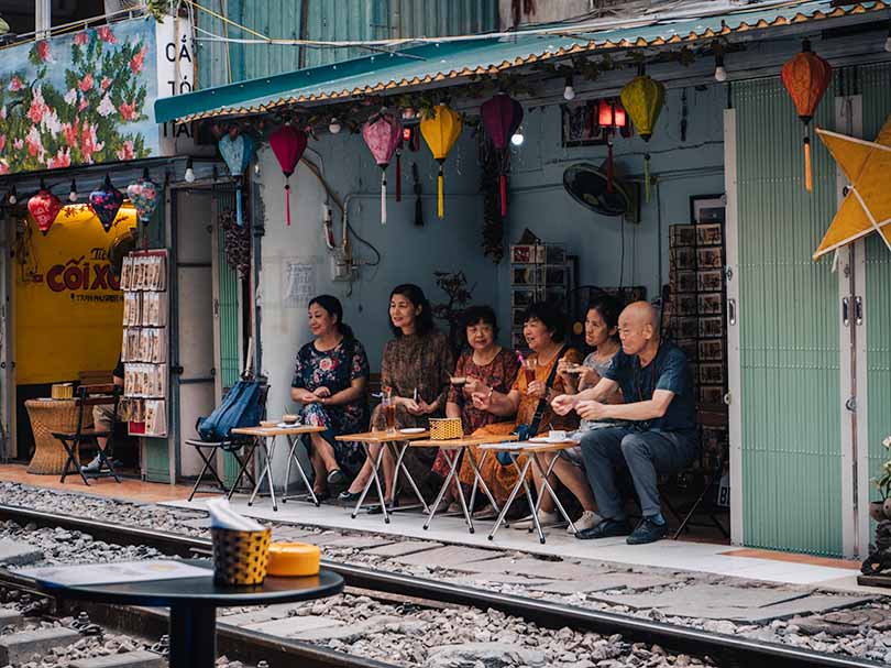 A group of people drinking coffee on Train Street in Hanoi, Vietnam