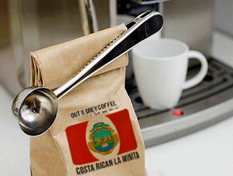 Silver coffee scoop attached to bag of beans via crocodile clip