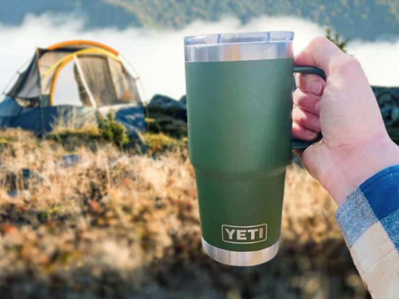 Yeti Rambler 20oz Travel Mug held up towards tent
