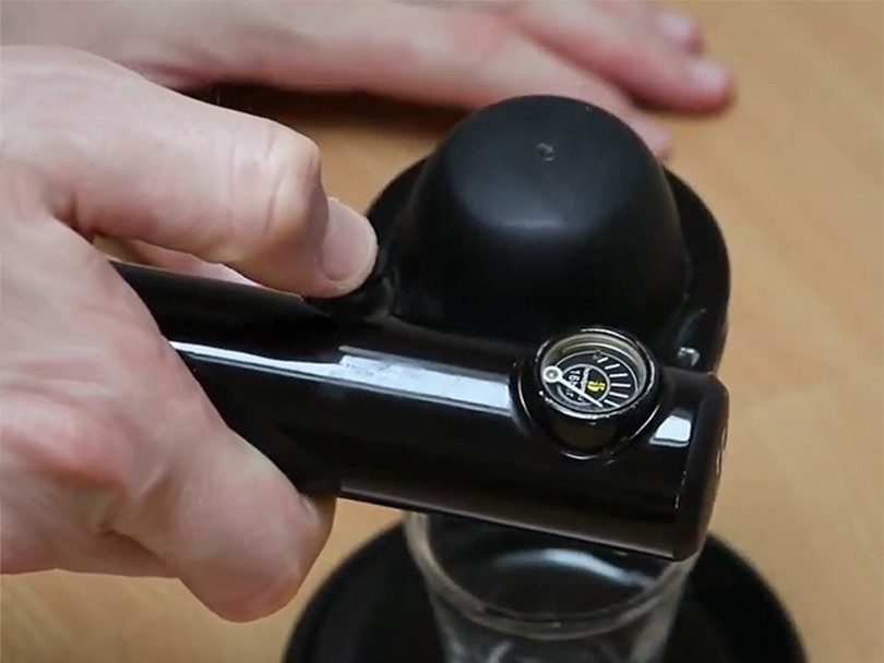 Pressing the "Infuse" button on the Handpresso Pump espresso maker