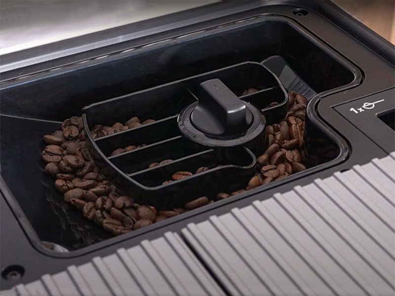 Close up of the Kitchen Aid KF6's removable bean hopper attached to the machine, with pre-ground coffee chute visible too